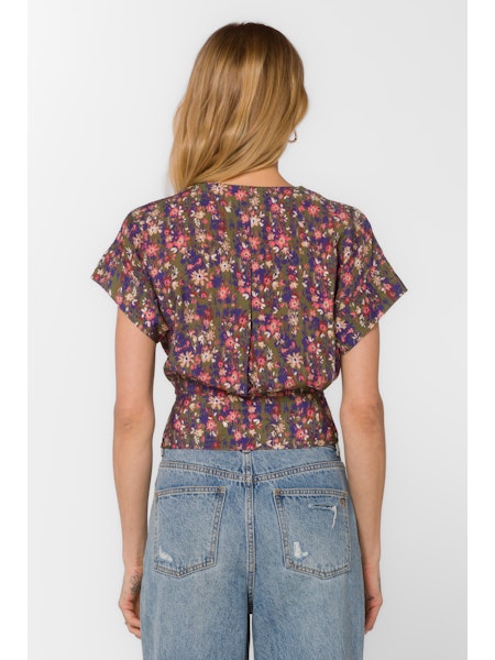 Person wearing a floral top and jeans on a white background