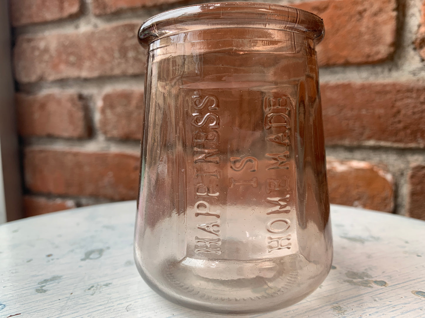 Brown glass votive holder that reads, "Happiness Is Homemade".