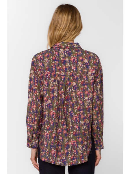 Person wearing a floral patterned shirt on a white background
