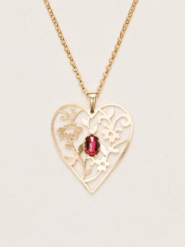Our Blooming Heart Necklace is a work of tender beauty. The art of metal cutting is gorgeously displayed in this elaborate depiction of emerging springtime foliage, where a dazzling gemstone blooms brightly from the center. 