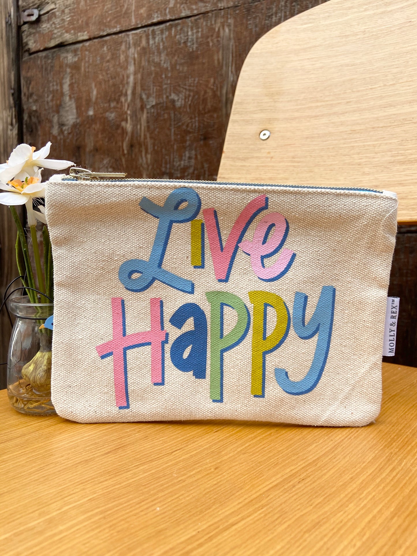 Brightly colored "Live Happy" canvas pouch by Molly & Rex. Measures 7 3/4" x 5 3/4".