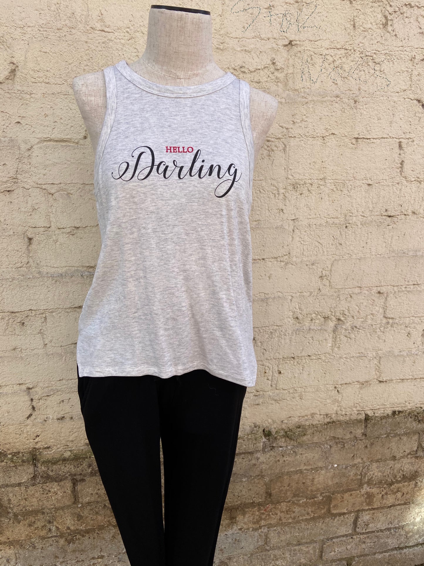 Relaxed black leggings with pockets, paired with a pebble grey tank that reads "Hello Darling" in red and black letters.