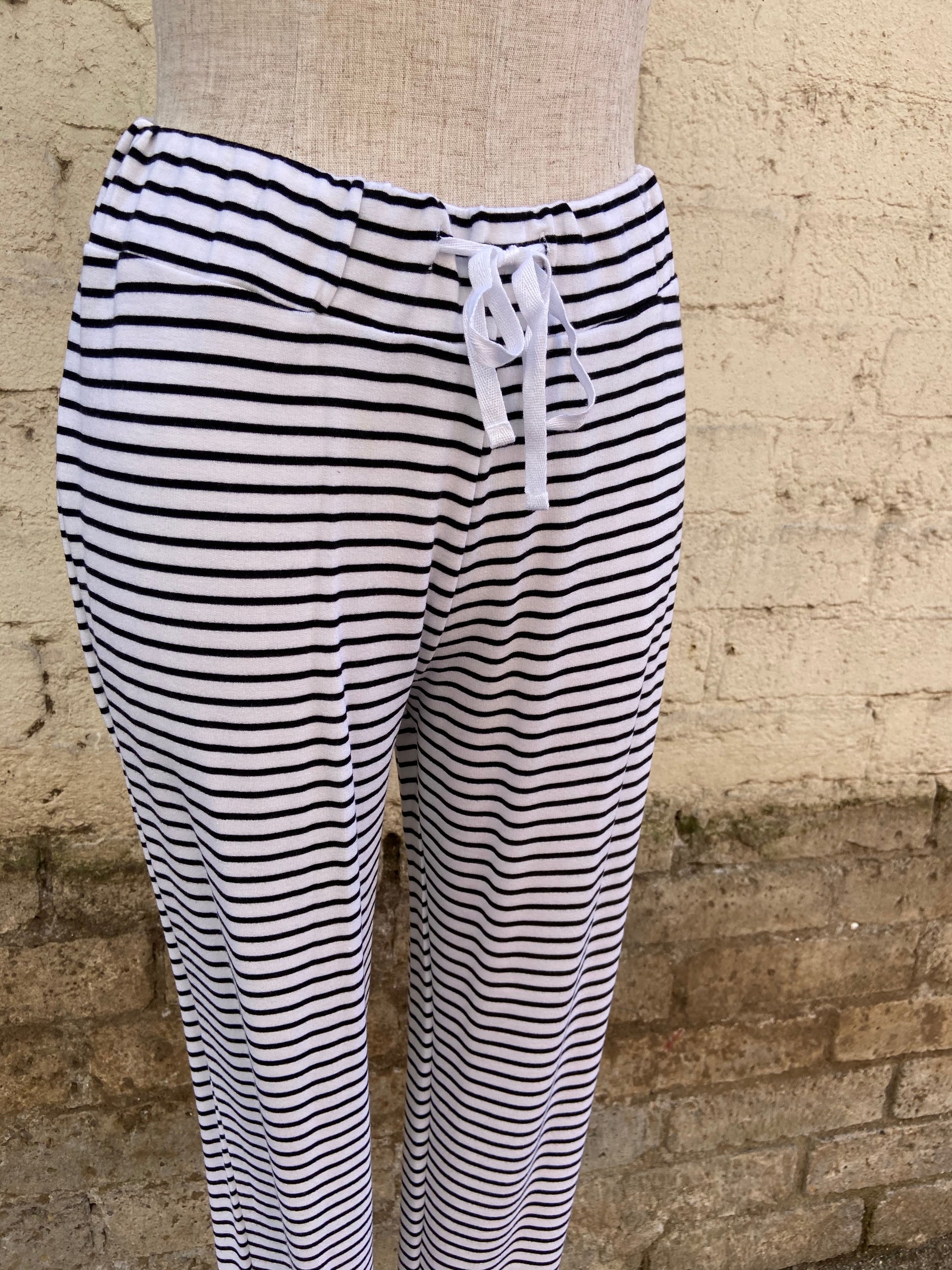 Whimsical lounge set that includes striped pants with a wide, drawstring waistband and a loose fitting sleeveless top. The top reads, "Bedtime, noun, 1. the time at which a person usually goes to bed: It's past my bedtime."