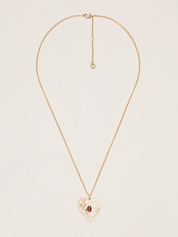 Our Blooming Heart Necklace is a work of tender beauty. The art of metal cutting is gorgeously displayed in this elaborate depiction of emerging springtime foliage, where a dazzling gemstone blooms brightly from the center. 